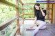 A woman in a black shirt and white stockings sitting on a porch.