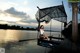 A woman sitting on a dock with a net over her head.