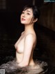 A naked asian woman in a pool of water.