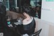 A woman sitting at a table with a tattoo on her back.