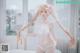 A woman in a white lingerie posing in a bathtub.