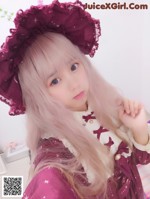 A girl with long blonde hair wearing a purple hat.