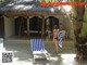 A woman in a bikini standing next to a beach chair.