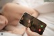 A woman laying in bed holding a cell phone.