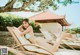 A woman in a blue bikini laying on a lounge chair.