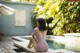 A woman in a pink bathing suit sitting by a pool.