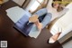 A woman sitting at a table with a pair of shoes on it.