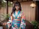 A woman in a blue and pink kimono posing for a picture.